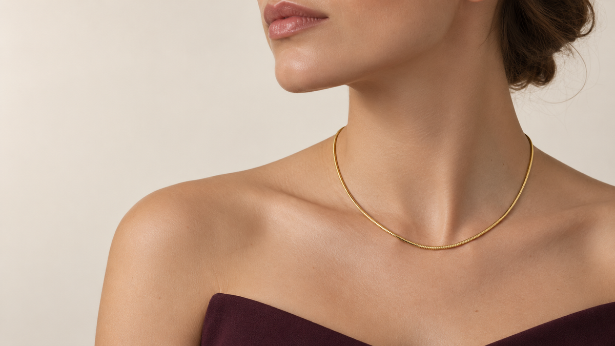 Woman wearing the gold Fieré L’Éclat Necklace in a studio close-up